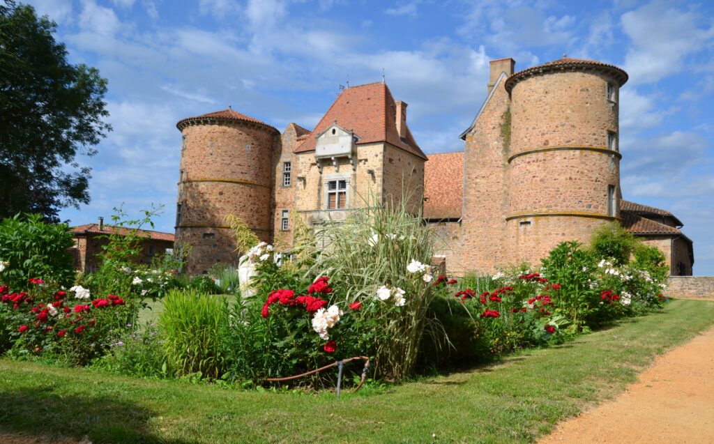 photo du château de saint marcel de félines avec des fleurs devant